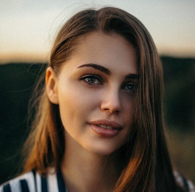 smiling woman wearing white and black pinstriped collared top